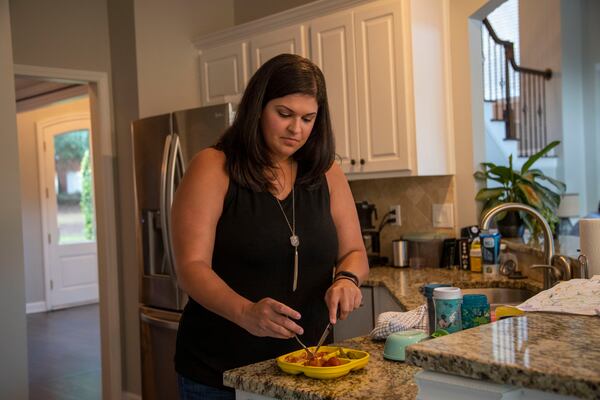 Sarah Beeson, Democratic candidate for state Senate District 56, prepares a plate of spaghetti for her son Turner before joining a virtual campaign event at her residence in Roswell on Sept. 10, 2020. (Alyssa Pointer / Alyssa.Pointer@ajc.com)