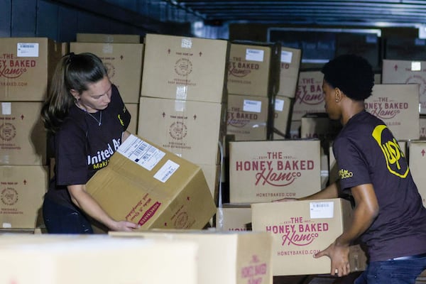 UPS package handlers Courtney Fielding and Kyree Traris unload a truck full of Honey Baked Hams to prepare them for distribution at the UPS S.M.A.R.T. Hub on Wednesday, Nov. 20, 2024.
(Miguel Martinez / AJC)