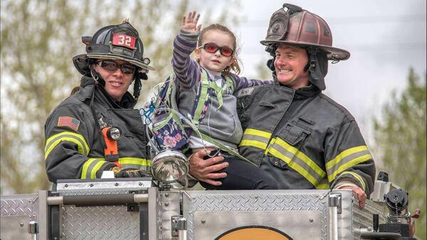 Olivia Gant waves from atop a fire truck in an April 2017 photo. The girl's mother, Kelly Turner, is accused of murder, fraud and other charges in her Aug. 20, 2017, death. Authorities say Turner, 41, lied about her daughter being terminally ill.