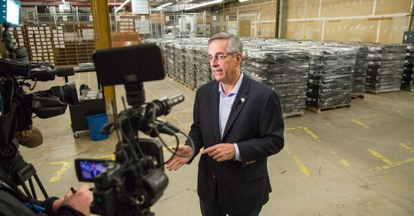 The Secretary of State Brad Raffensperger talks to the media in front of old voting machines while waiting for the largest shipment of Georgia’s new secure paper-ballot voting machines at the Dekalb County Voter Registration & Elections offices on Dec. 30th, 2019. 2839 units are to be delivered for Dekalb County. (Photo by Phil Skinner).