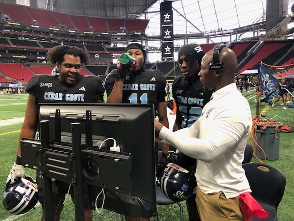 Cedar Grove coach John Adams talks strategy with defensive players (from left) Kyle Mosley, Wesley Brown and Javon Beckford during the team’s GHSA Class 3A state championship game against Savannah Christian, Dec. 13, 2023 at Mercedes-Benz Stadium. (Photo by Ken Sugiura/The Atlanta Journal-Constitution)