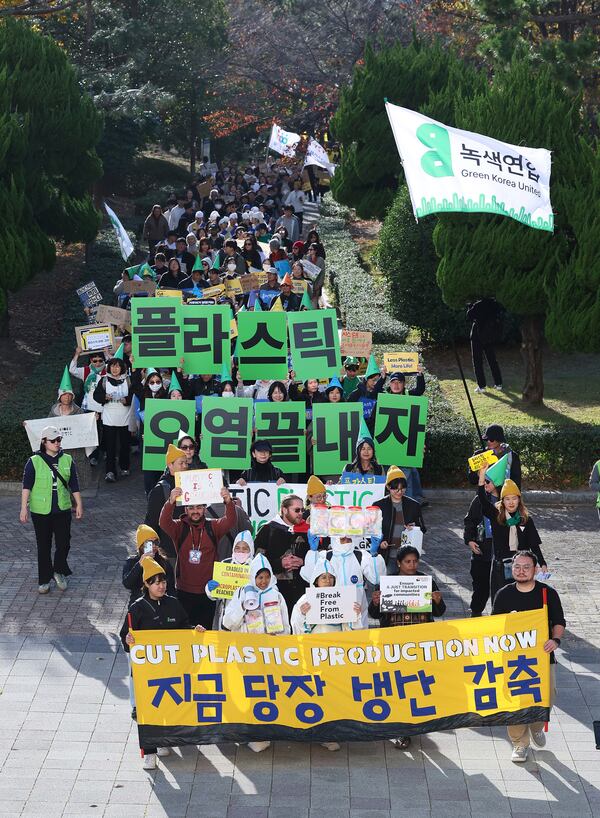 Environment activists march during a rally calling for a strong global plastics treaty ahead of the fifth session of the Intergovernmental Negotiating Committee on Plastic Pollution which sets to be held from Nov. 25 to Dec. 1 in Busan, South Korea, Saturday, Nov. 23, 2024. A signs at center reads "Let's end plastic pollution." (Son Hyung-joo/Yonhap via AP)