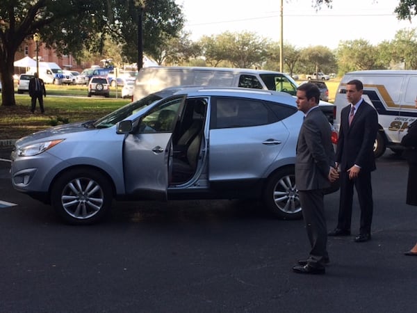 Prosecutors Chuck Boring (foreground) and Jesse Evans stand by the SUV of Justin Ross Harris in the parking lot of the Glynn County Courthouse in Brunswick, Ga., during Harris' murder trial on Thursday, Oct. 27, 2016. (Christian Boone / cboone@ajc.com)