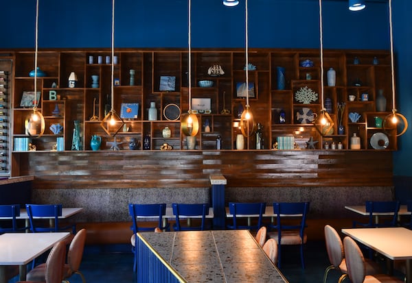 The large display shelving at Just Brunch features lots of blue items including many of owner and chef Keith Kash's mother's personal items, including albums, eight track tapes and pottery.  (CHRIS HUNT FOR THE ATLANTA JOURNAL-CONSTITUTION)