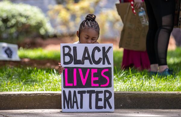 06/01/2020 - Atlanta, Georgia  - Corri Griffith, 5, takes a rest as she and her father Corey Griffith, who was close by, listen to demonstrators speak during a rally near the steps of Atlanta City Hall during the fourth day of protests in Atlanta, Monday, June 1, 2020. Corri and her father created the Black Lives Matter sign that she held during the rally. (ALYSSA POINTER / ALYSSA.POINTER@AJC.COM)