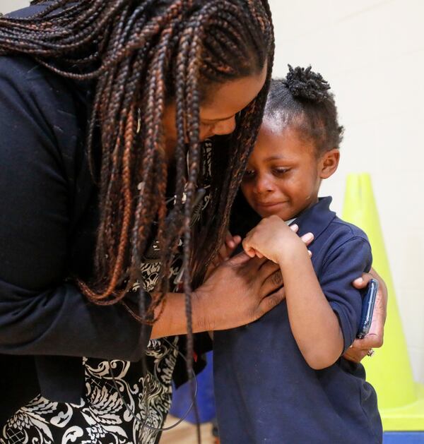 Harper-Archer Elementary School Principal Dione Simon Taylor comforts a student who got hit by a ball during the monthly "Gym Jam," an event to reward students who have earned enough points to attend on Oct. 24, 2019. Bob Andres / robert.andres@ajc.com