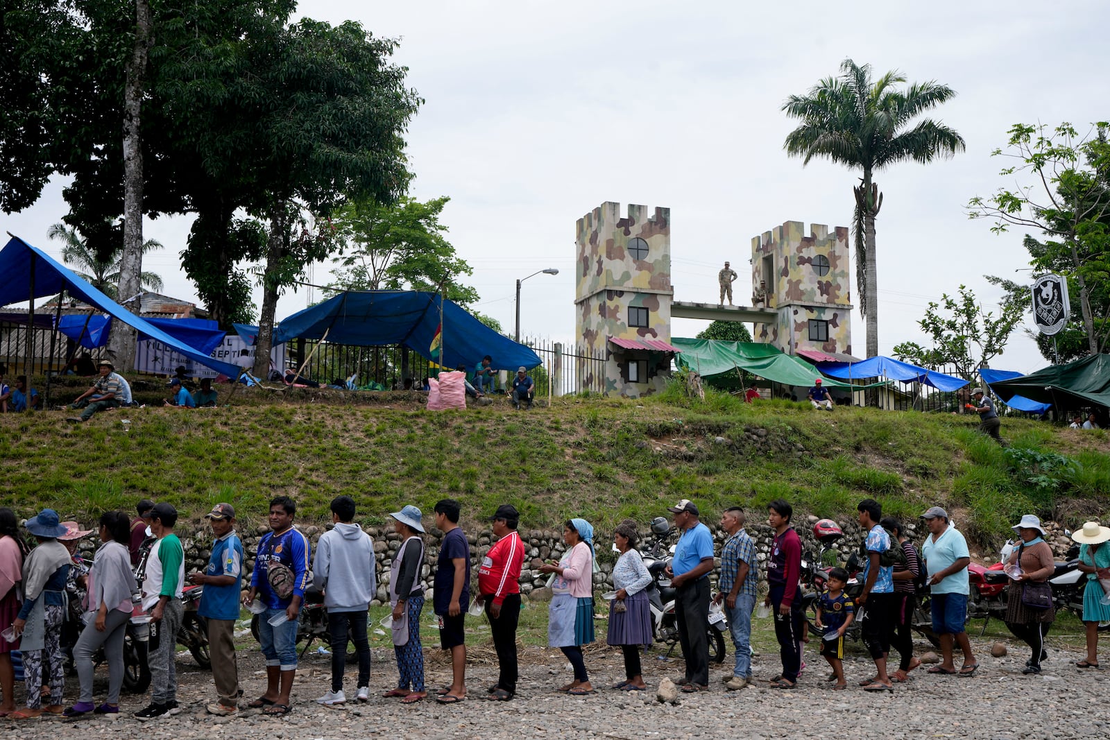 Followers of former President Evo Morales line up to receive food in Villa Tunari, Chapare region, Bolivia, Sunday, Nov. 3, 2024, amid an ongoing political conflict between Morales and the government of President Luis Arce. (AP Photo/Juan Karita)