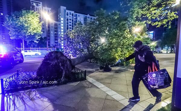 A fallen tree blocked the southbound lanes of Peachtree Street at 12th Street on Monday morning. JOHN SPINK / JSPINK@AJC.COM.