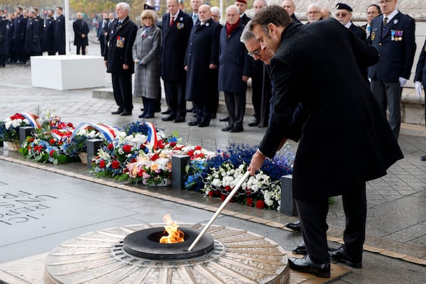 French President Emmanuel Macron, right, and British Prime Minister Keir Starmer revive the flame on the Unknown Soldiers's Tomb under the Arc de Triomphe during commemorations marking the 106th anniversary of the November 11, 1918, Armistice, ending World War I, at the Arc de Triomphe in Paris, Monday, Nov. 11, 2024. ( Ludovic Marin, Pool via AP)