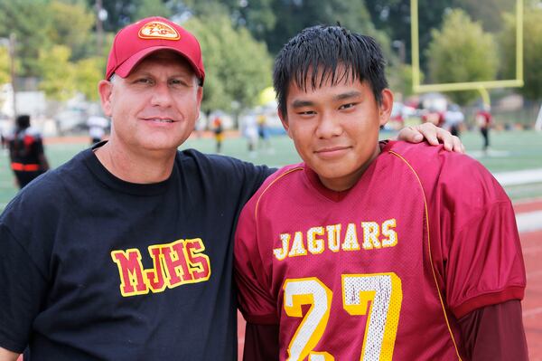 An American family portrait: Jack Breedlove in his football practice gear and his father, Jeff. (BOB ANDRES / BANDRES@AJC.COM)