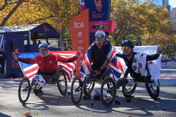 First place finisher Daniel Romanchuck, left, poses with second place finisher David Weir, of England, and Tomoki Zuzuki, of Japan, right, after winning the men's wheelchair division of the New York City Marathon, Sunday, Nov. 3, 2024, in New York. (AP Photo/Frank Franklin II)