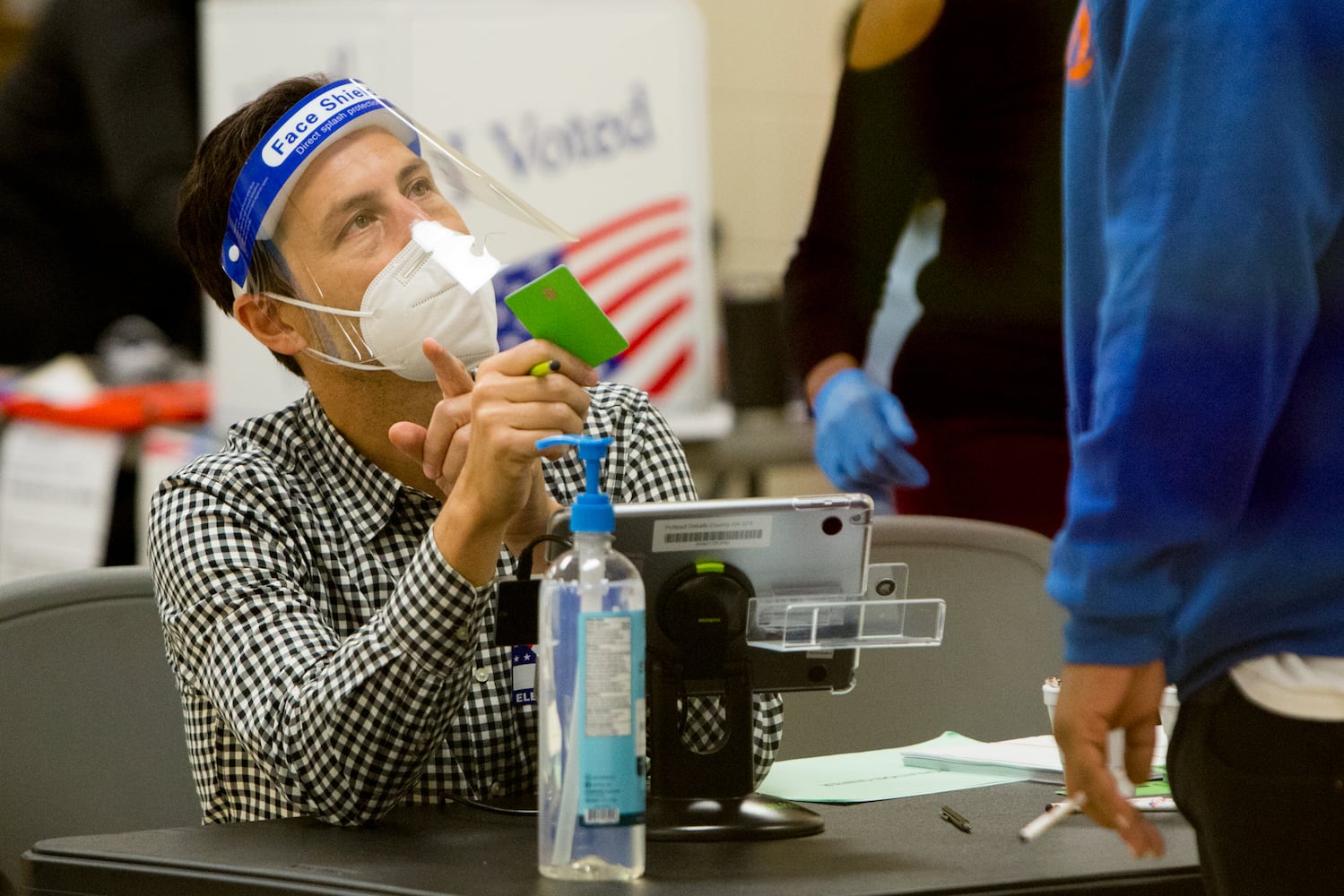 Poll worker Nickolas DeLuca hands a voter his card at the Coan Park Recreation Center on election day Nov 3rd, 2020. The poll manager reported a lighter than normal turn out early in the day but had a good early voting numbers. PHIL SKINNER FOR THE ATANTA JOURNAL-CONSTITUTION