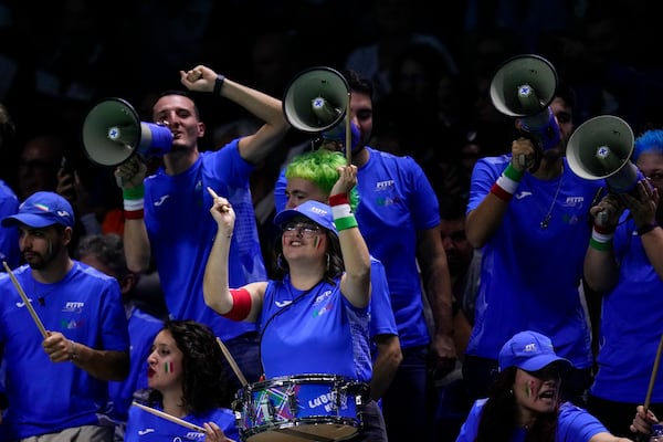 Italy supporters cheer during the match between Jannik Sinner and Argentina's Sebastian Baez during a Davis Cup quarterfinal match at the Martin Carpena Sports Hall in Malaga, southern Spain, on Thursday, Nov. 21, 2024. (AP Photo/Manu Fernandez)