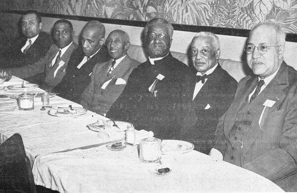 Sigma Royalty. In this 1949 photo, two of the fraternity's founders A. Langston Taylor (second from left) and Leonard F. Morse (wearing the religious collar), attend a dinner with the brothers. Scholar Alain Leroy Locke is second from right.