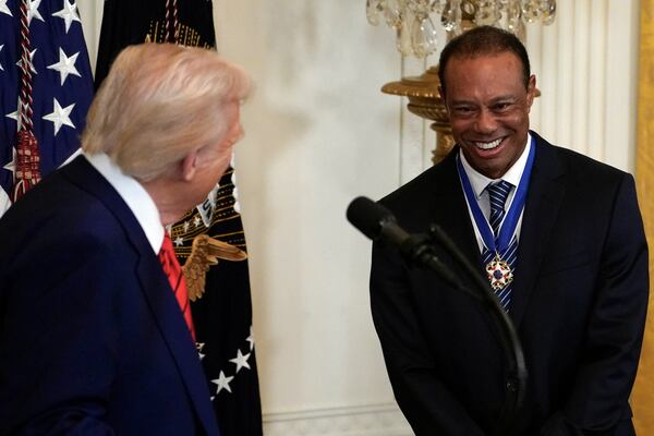 President Donald speaks with Tiger Woods during a reception for Black History Month in the East Room of the White House Thursday, Feb. 20, 2025. (Pool via AP)