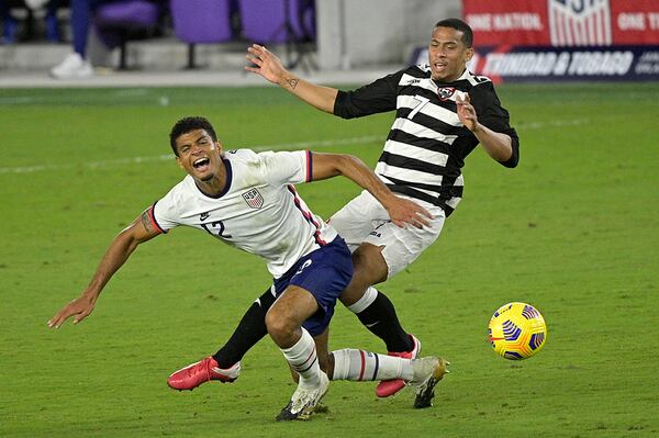 United States defender Miles Robinson (12) and Trinidad and Tobago forward Ryan Telfer (7) collide while going for the ball during the second half of an international friendly soccer match, Sunday, Jan. 31, 2021, in Orlando, Fla. (Phelan M. Ebenhack/AP)