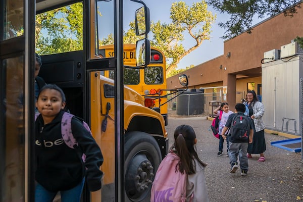 Social worker Mary Schmauss, rear right, greets students as they arrive for school, Tuesday, Oct. 1, 2024, at Algodones Elementary School in Algodones, N.M. (AP Photo/Roberto E. Rosales)