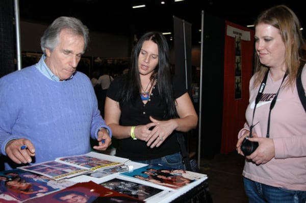 This won’t be Henry Winkler’s first time attracting crowds in Atlanta. This 2010 photo shows him autographing an event booklet for Ange Alex (C) and April Bumps (R) at the Wizard World Atlanta Comic Con at Cobb Galleria Centre.