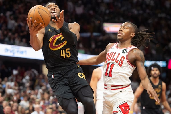 Cleveland Cavaliers' Donovan Mitchell (45) drives to the basket in front of Chicago Bulls' Ayo Dosunmu (11) during the second half of an Emirates NBA Cup basketball game in Cleveland, Friday, Nov. 15, 2024. (AP Photo/Phil Long)