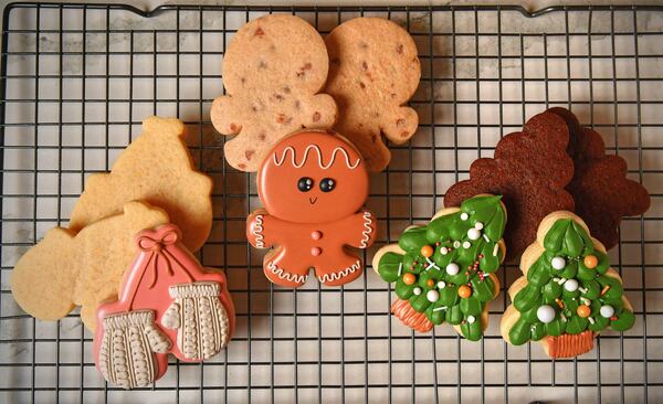 Undecorated and decorated versions of the cookies: (from left) lemon (mittens), cinnamon (gingerbread man), and chocolate (tree). (Styling by Sam Opdenbosch / Chris Hunt for the AJC)