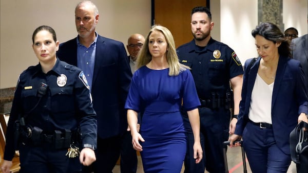 Ex-Dallas police Officer Amber Guyger, in blue, walks into court Monday, Sept. 23, 2019, for her murder trial in the killing of unarmed neighbor Botham Jean, who Guyger shot after going into Jean's apartment by mistake last year.