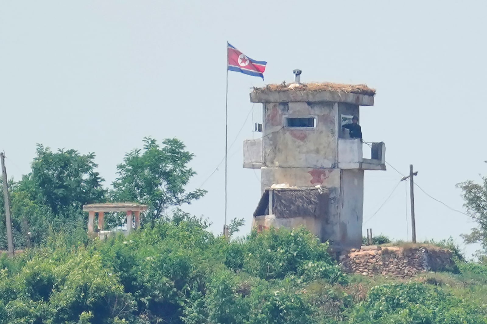 FILE - A North Korean soldier stands at the North's military guard post as a North Korean flag flutters in the wind, seen from Paju, South Korea, Wednesday, June 26, 2024. (AP Photo/Lee Jin-man, File)