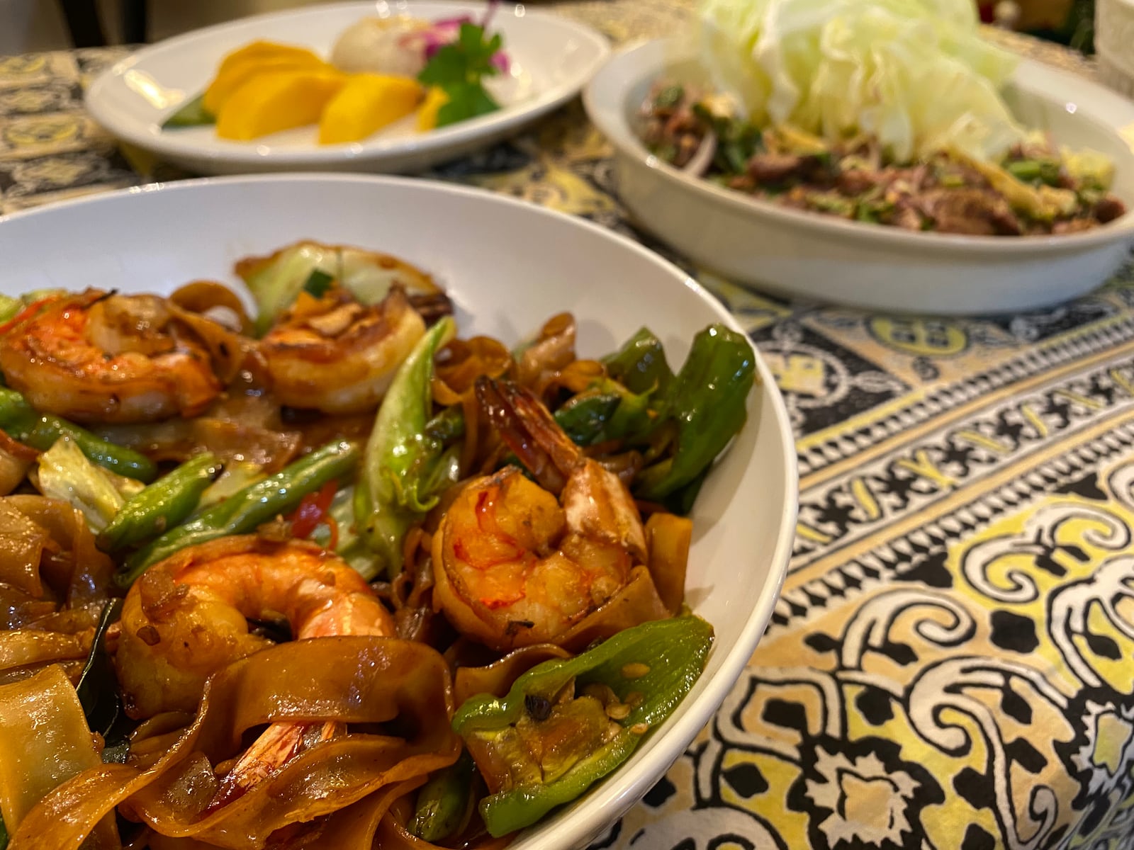 A selection of dishes from Banana Leaf includes (clockwise from bottom left): pad kee mao, also known as drunken noodle; sweet sticky rice with mango; and nua nam tok (Thai beef salad). Ligaya Figueras/ligaya.figueras@ajc.com
