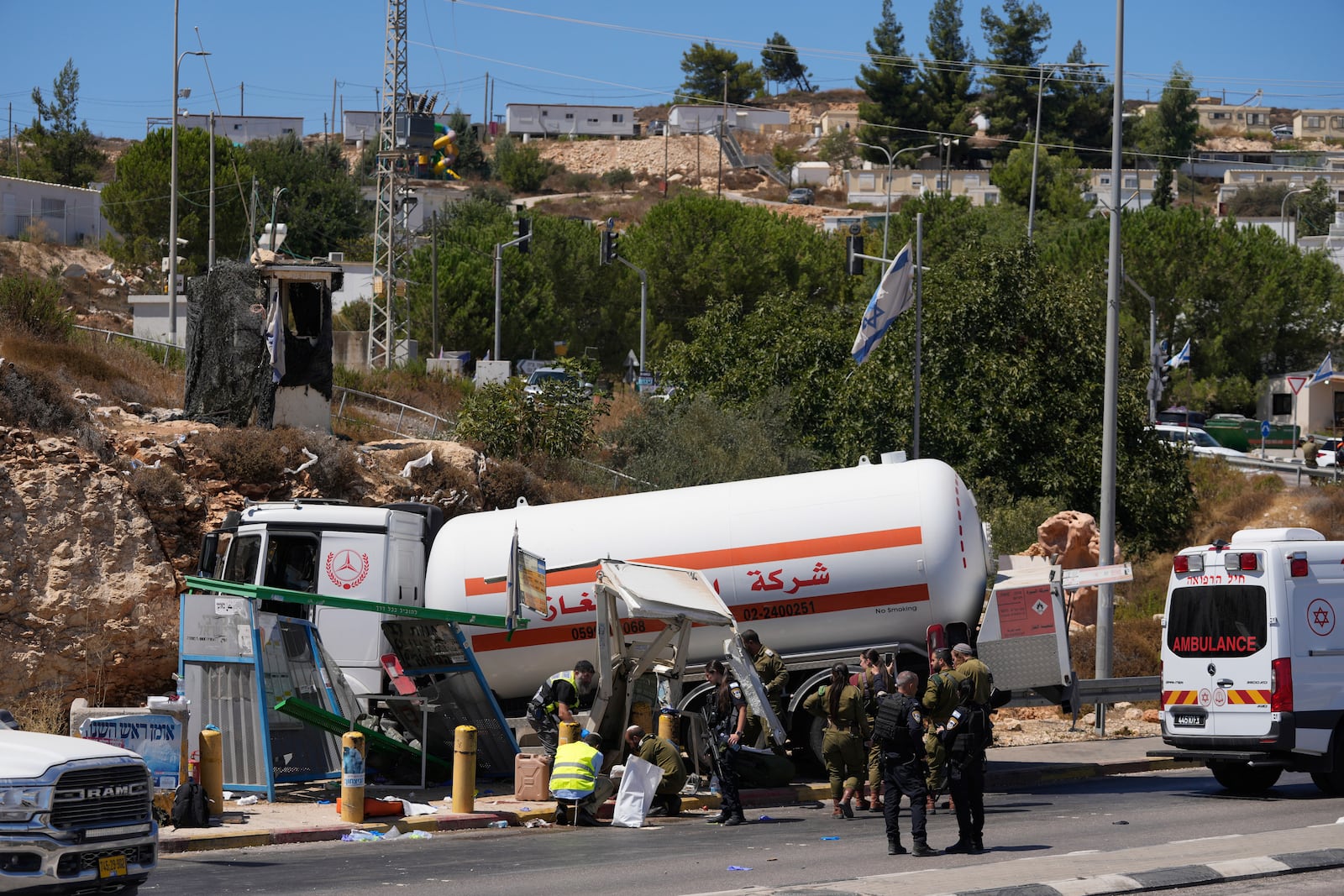 Israeli security forces inspect the scene of what they say is a Palestinian ramming attack at a bus station near the West Bank Jewish settlement of Beit El, Wednesday, Sept. 11, 2024. (AP Photo/Ohad Zwigenberg)