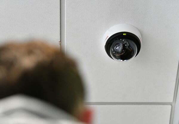 Ethan King, technician with Compass Security Solutions, shows one of security cameras at a car dealership in Sandy Springs on Thursday, April 22, 2021. (Hyosub Shin / Hyosub.Shin@ajc.com)