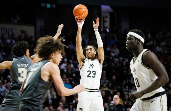 Wake Forest's Hunter Sallis (23) shoots a three-pointer over Georgia Tech's Jaeden Mustaf (3) in the first half of an NCAA college basketball game on Saturday, March 8, 2025, in Winston-Salem, N.C. (Allison Lee Isley/The Winston-Salem Journal via AP)