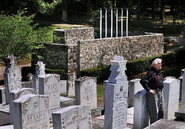 Benjamin Hirsch, a Holocaust survivor and the Atlanta architect who designed the Holocaust Memorial at Greenwood Cemetery (in background), stands near the memorial which was placed on the National Register of Historic Places in 2008. The memorial features six large white poles with gas flames on top, which represent the six million Jews killed by the Nazi regime during WWII. Rich Addicks / AJC