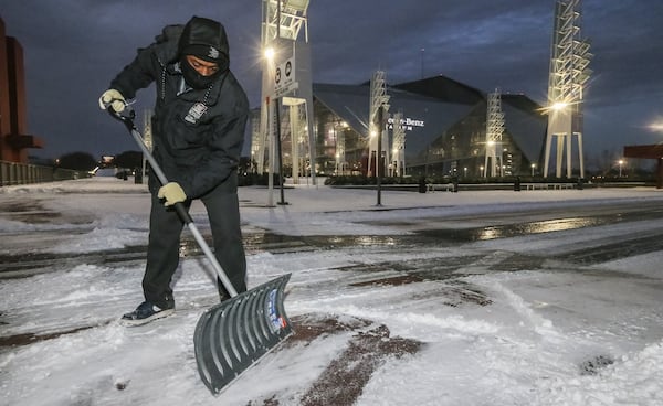 Melvin Tucker braved the cold to remove snow and ice at the Georgia World Congress Center on Wednesday.  JOHN SPINK/JSPINK@AJC.COM