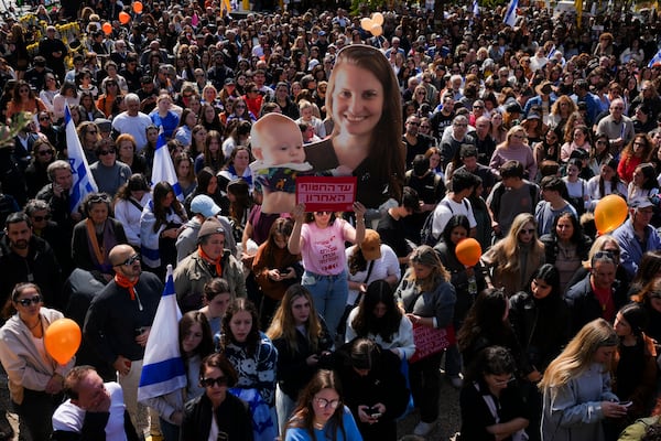 People watch a live broadcast from the funeral of slain hostages Shiri Bibas and her two children, Ariel and Kfir, at a plaza known as the Hostages Square in Tel Aviv, Israel, Wednesday, Feb. 26, 2025. The mother and her two children were abducted by Hamas on Oct. 7, 2023, and their remains were returned from Gaza to Israel last week as part of a ceasefire agreement with Hamas. (AP Photo/Ariel Schalit)