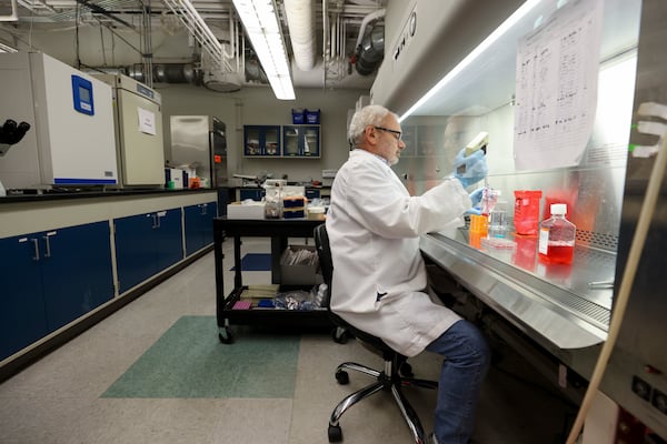 GeoVax director of vaccine development Arban Domi works in the biosafety cabinets at the GeoVax laboratory (Jason Getz / AJC)
