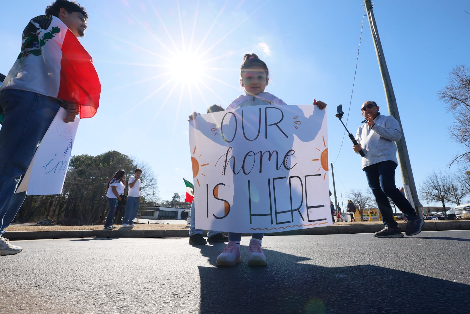 Litzy P. (3) holds a sign as she arrives at Plaza Fiesta with family members to a pro-immigrant rally on Saturday, Feb. 1, 2025.
(Miguel Martinez/ AJC)