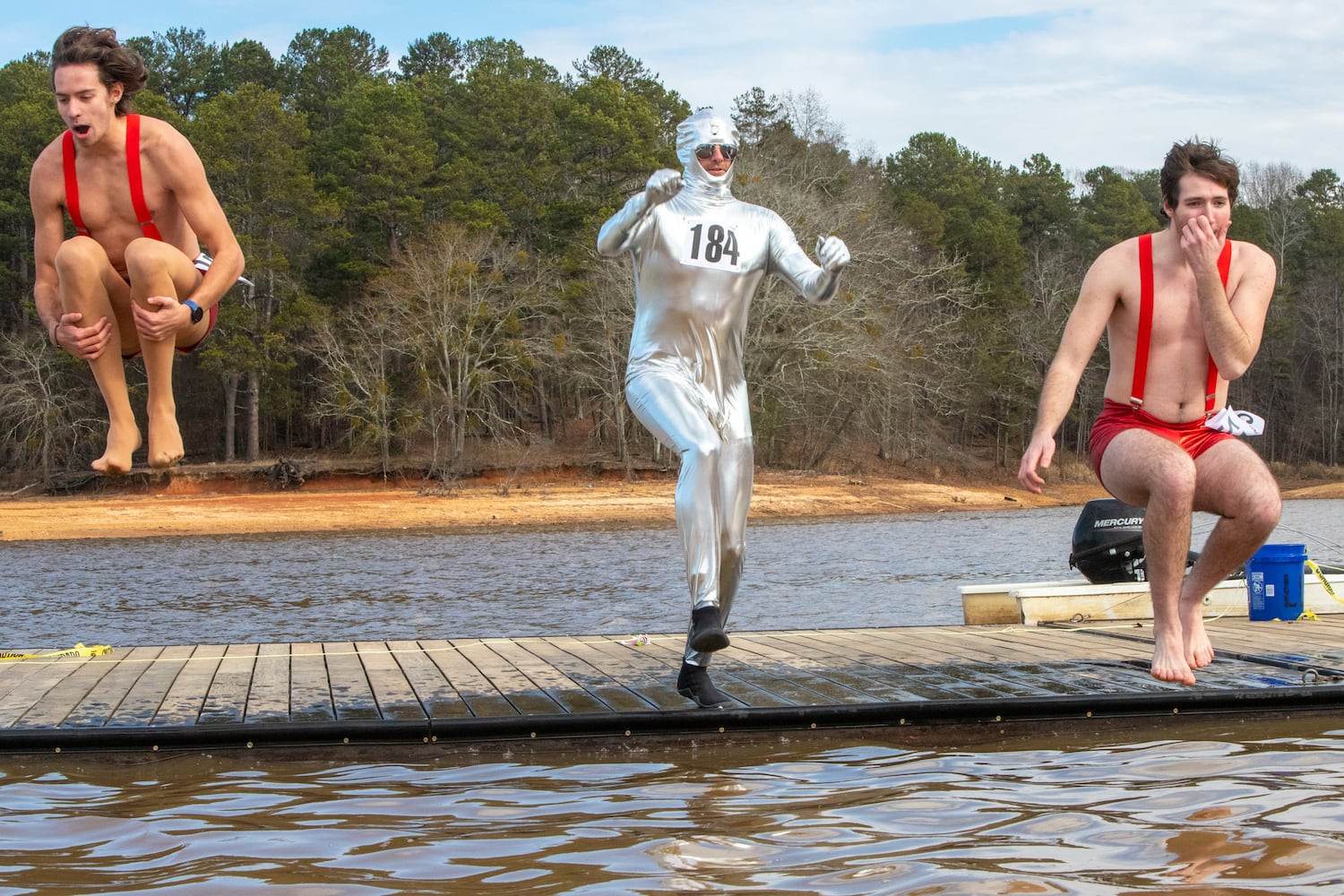 Caleb Collins, from left, John Collins and Linden Martin participate in the 26th annual Polar Bear Paddle and Plunge at Lake Lanier Olympic Park on Monday, Jan 1, 2024.  There is a category of best costume in the event, as well as best splash and fastest exit from the lake. (Jenni Girtman for The Atlanta Journal-Constitution)