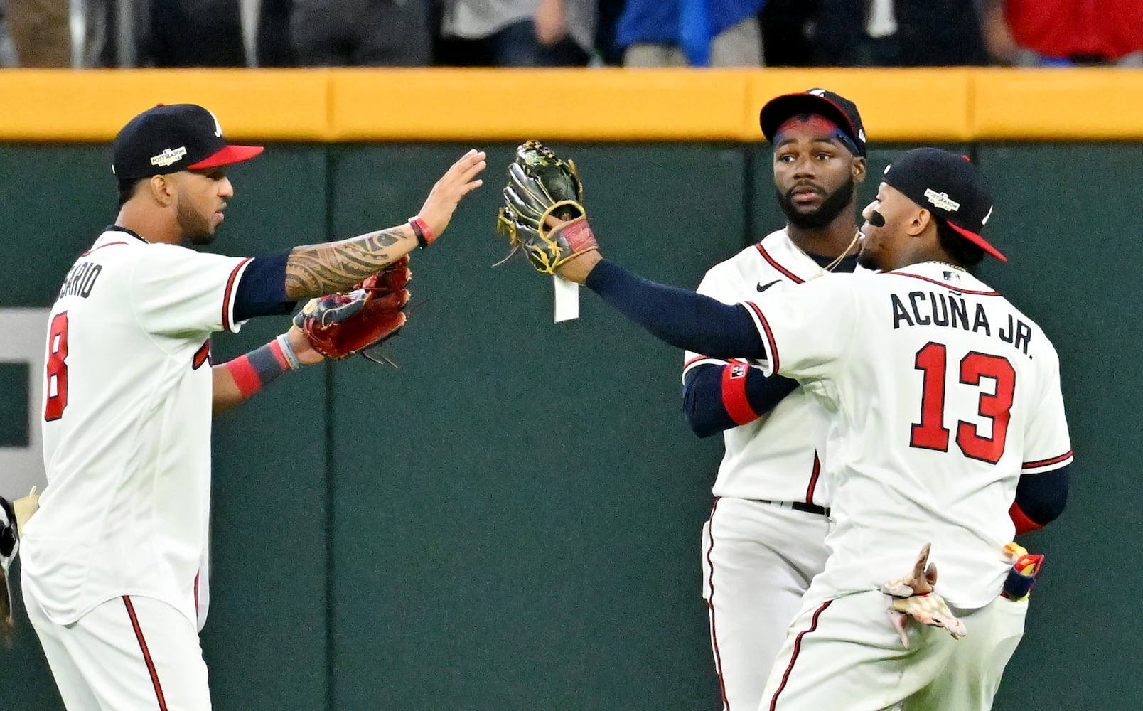 Atlanta Braves outfielders Ronald Acuna (13), Michael Harris, and Eddie Rosario celebrate a 3-0 win over the Philadelphia Phillies during the ninth inning of game two of the National League Division Series at Truist Park in Atlanta on Wednesday, October 12, 2022. (Hyosub Shin / Hyosub.Shin@ajc.com)