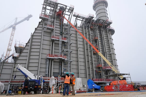 Workers talk at Entergy's Orange County Advanced Power Station, a 1,215-megawatt facility under construction, Monday, Feb. 24, 2025, in Orange, Texas. (AP Photo/David J. Phillip)