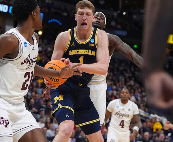 Michigan center Danny Wolf, front right, pulls in a rebound as Texas A&M forward Pharrel Payne, left, and guard Manny Obaseki, back, defend during the first half in the second round of the NCAA college basketball tournament Saturday, March 22, 2025, in Denver. (AP Photo/David Zalubowski)