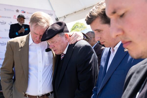 Rodney Cook Jr., founder and president of the National Monuments Foundation, left, embraces Clyde Strickland during a prayer at the unveiling ceremony for a statue of Dr. Martin Luther King Jr. in Rodney Cook Sr. Peace Park in Atlanta on Saturday, April 1, 2023. The park is named after Cook’s father.  (Ben Gray / Ben@BenGray.com)