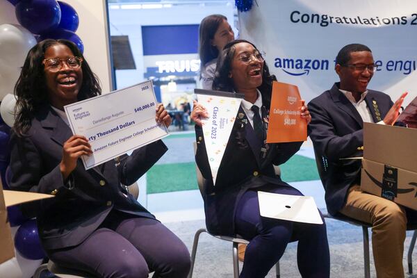 Arabia Mountain High School seniors from left to right: Daniellange Auguste, Toni Dismuke, and Isaiah Fleming celebrate as they all receive a $40,000 Amazon Future Engineer Scholarship and a paid internship at Amazon at the Junior Achievement Discovery Center at the Georgia World Congress Center, Tuesday, April 18, 2023, in Atlanta. Eight students represented from the Atlanta, Clayton County and DeKalb County school systems received the scholarships. (Jason Getz / Jason.Getz@ajc.com)