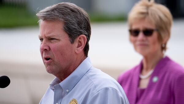 Gov. Brian Kemp  talks about the coronavirus in Georgia during a press conference outside the state Capitol on Monday, April 13, 2020. Listening is Dr. Kathleen Toomey, commissioner of the Georgia Department of Public Health. (credit: Ben@BenGray.com for the Atlanta Journal-Constitution)