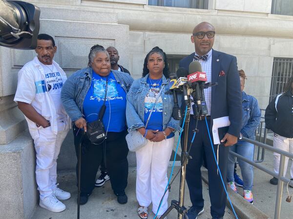 The family of Johnny Hollman speaks with reporters Monday before meeting with Fulton County District Attorney Fani Willis. 