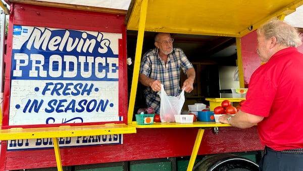 Melvin Self bags some fruit for a customer at Melvin's Produce, which sits just off Exit 142 on I-75 along Georgia 96 in Middle Georgia's Peach County. (Joe Kovac Jr. / AJC)