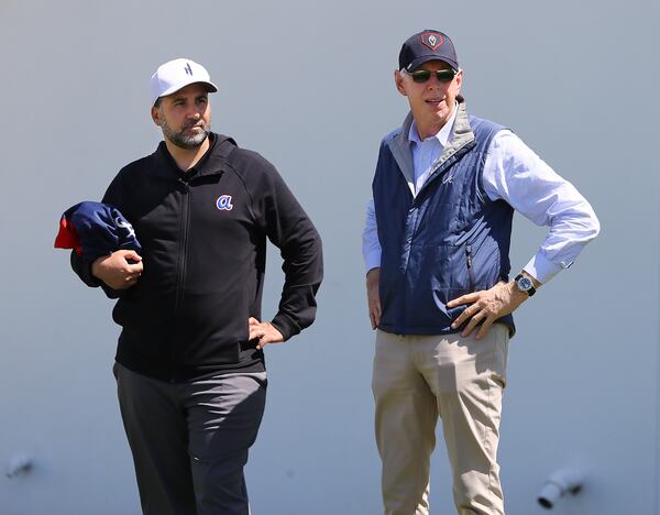 Braves GM Alex Anthopoulos (left) and Braves Chairman Terry McGuirk watch the first day of team practice at spring training on March 14 in North Port, Fla. (Curtis Compton / Curtis.Compton@ajc.com)