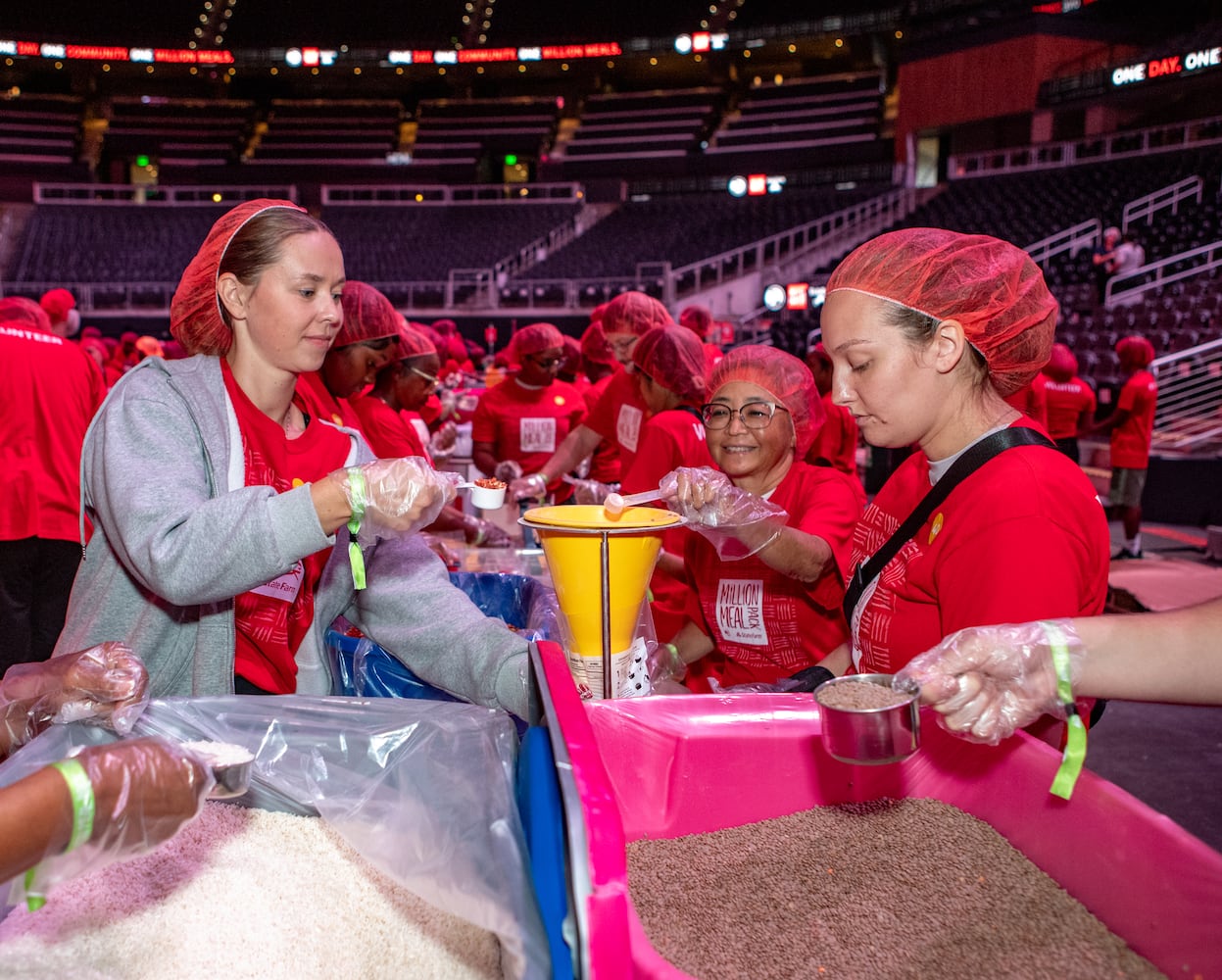 Rachael Starr (left), Stephanie Davis and Delaney Rhode pack red lentil jambalaya kits.  (Jenni Girtman for The Atlanta Journal-Constitution)