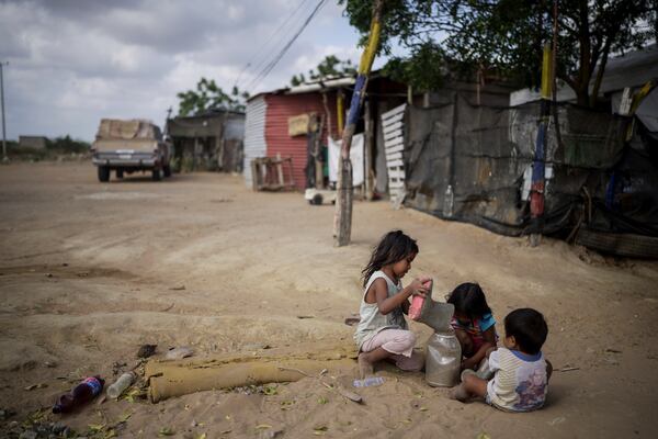 Children play with sand in the La Voz que Clama neighborhood on the outskirts of Maicao, Colombia, Wednesday, Feb. 5, 2025. (AP Photo/Ivan Valencia)