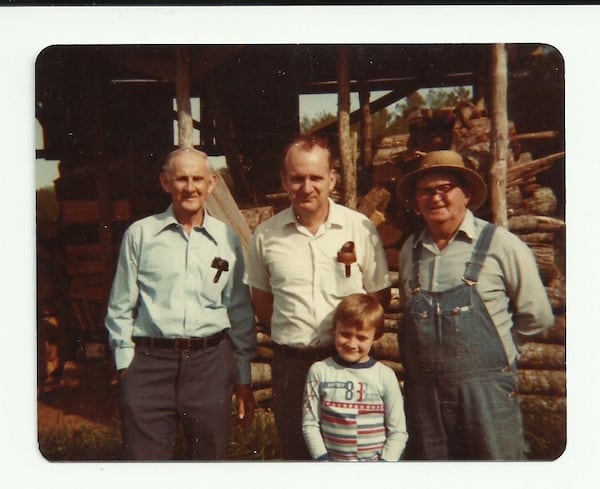 The Capps family has a long tradition of dairy and vegetable farming in DeKalb and Gwinnett counties. From left here are Emmett Capps, John Capps and Woodrow Cheek, with a young Mark Capps standing in front of them. Courtesy of Mark Capps