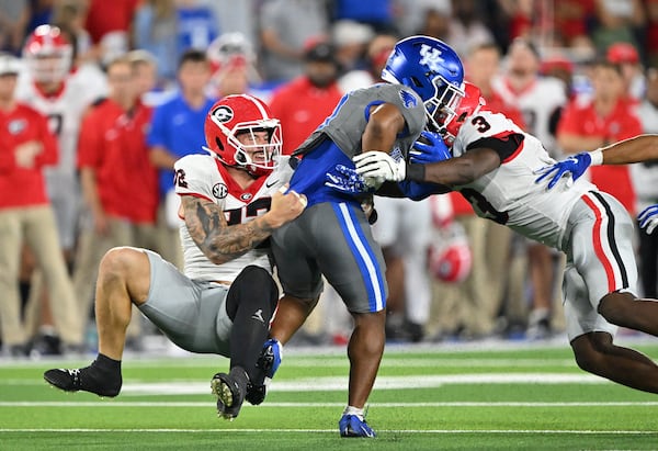 Kentucky running back Demie Sumo-Karngbaye (0) gets tackled by Georgia linebacker Chaz Chambliss (32) and Georgia linebacker CJ Allen (3) during the second half in an NCAA football game at Kroger Field, Saturday, September 14, 2024,  in Lexington, Kentucky. Georgia won 13-12 over Kentucky. (Hyosub Shin / AJC)