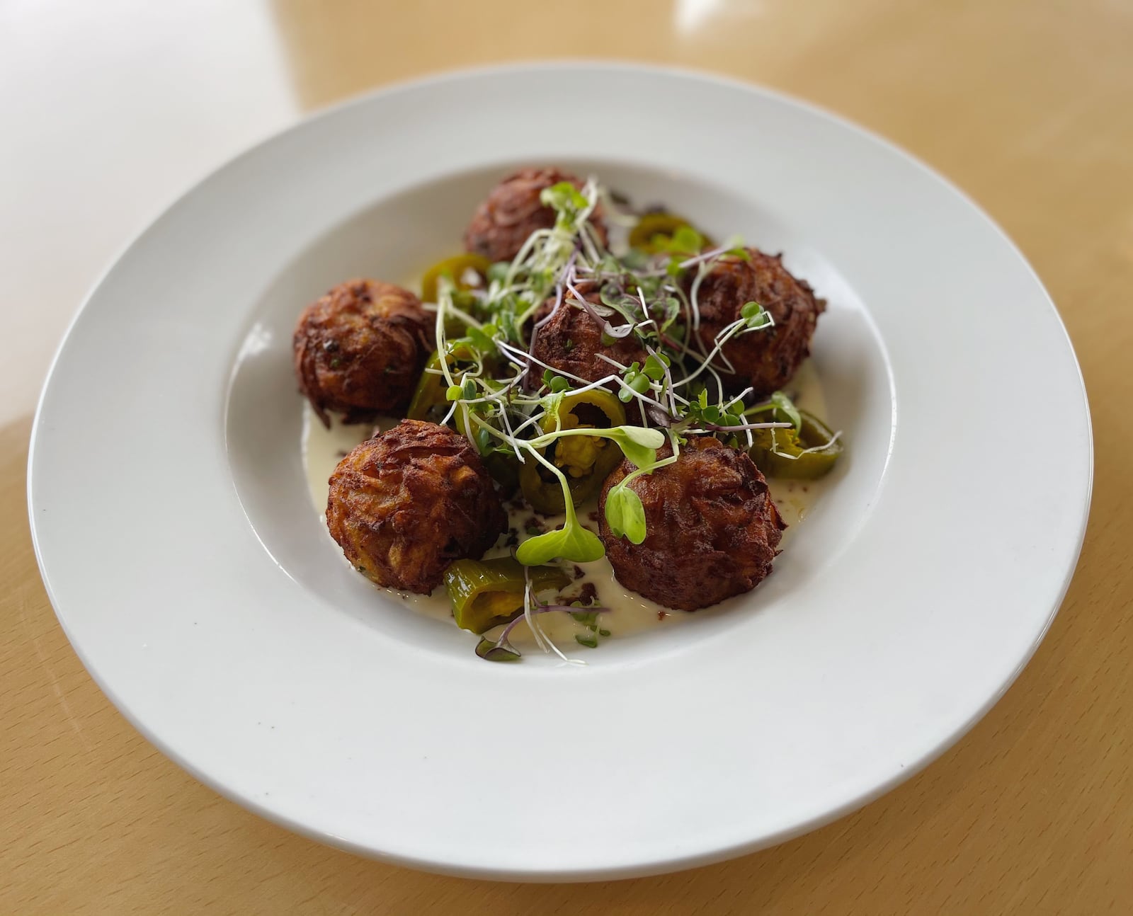 The House-made Tots with warm beer cheese, jalapeno and Beeler’s bacon is a popular appetizer at the Curious Pig. /
Courtesy of the Curious Pig